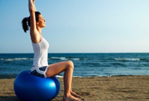 top-10-fitness-facts-s3-photo-of-woman-on-exercise-ball-at-beach